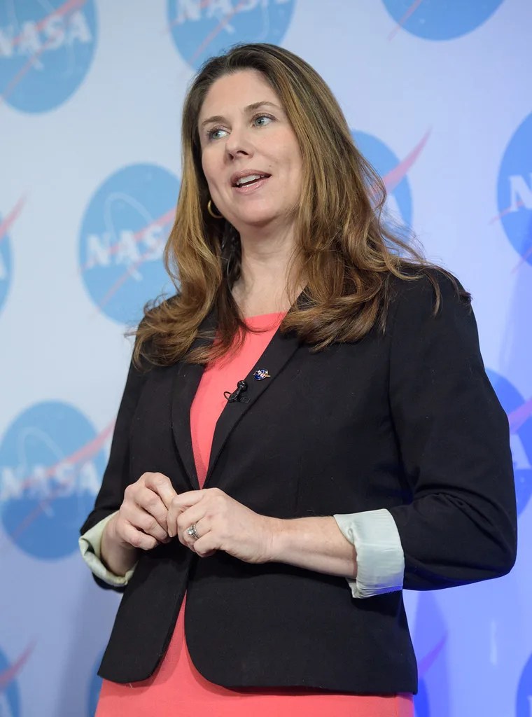 Photo of woman standing in front of a screen.