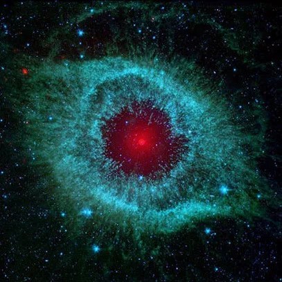 Cosmic starlet known as the Helix Nebula that resembles a teal eye with a red pupil.