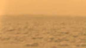 An orange, hazy view of Titan's surface.